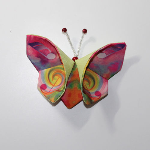 Schmetterlingsbroche mit farbenfrohen Musikmotiven