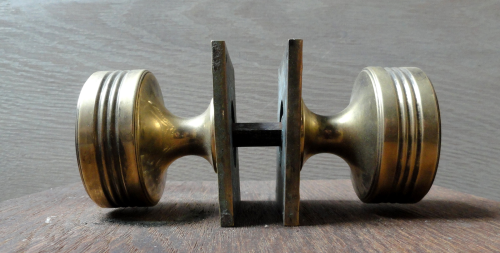 A Pair of Brass Door Knobs with a Square Decorative Cast Backplate.