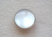 Silver rimmed pearly button.